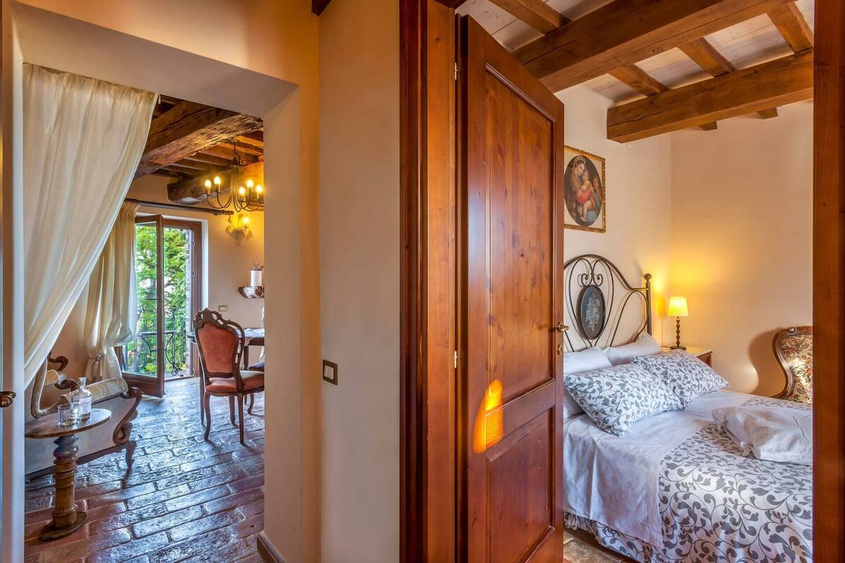 Una habitación con cama, una silla, una mesa y techo de madera.