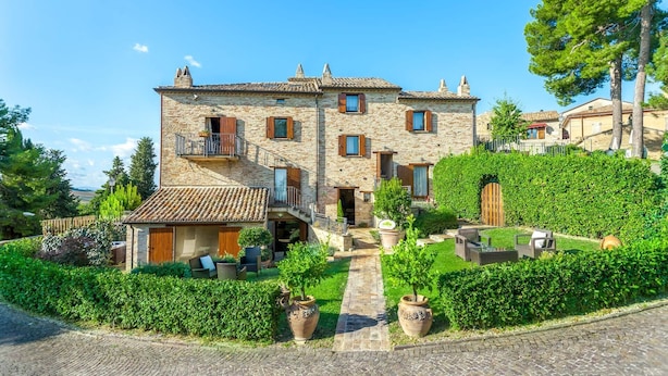 A stone building with a tiled roof, a small balcony, and a paved pathway leading to the entrance. - Mons Major Relais (Colli al Metauro)