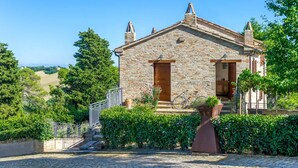 A stone building with a wooden door, a small porch, and a bicycle parked outside. - Mons Major Relais (Colli al Metauro)