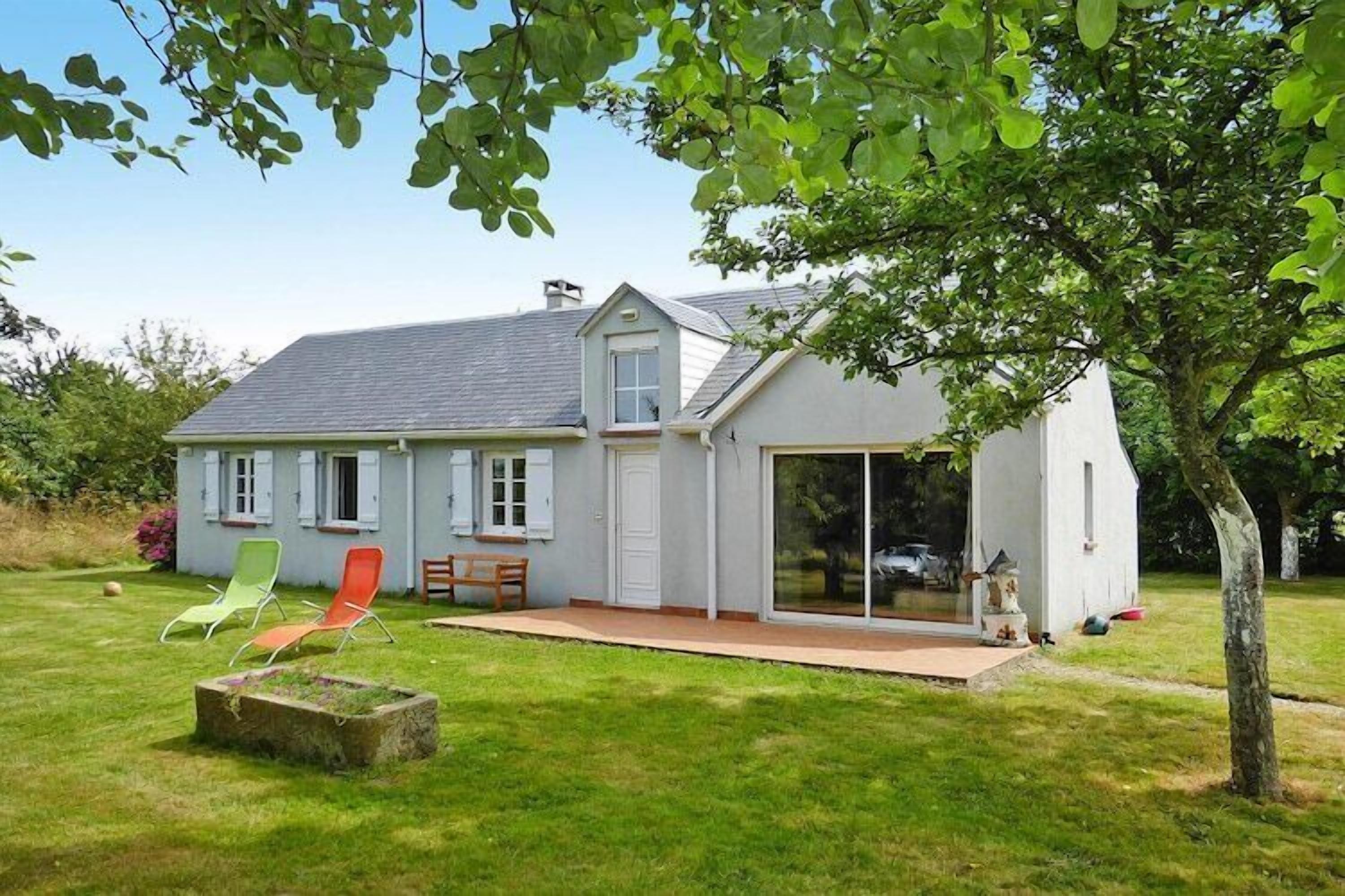 A house with a patio, a sliding glass door, and a small garden area.