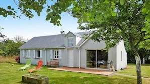Ein Haus mit Terrasse, Glastür und kleinem Garten.