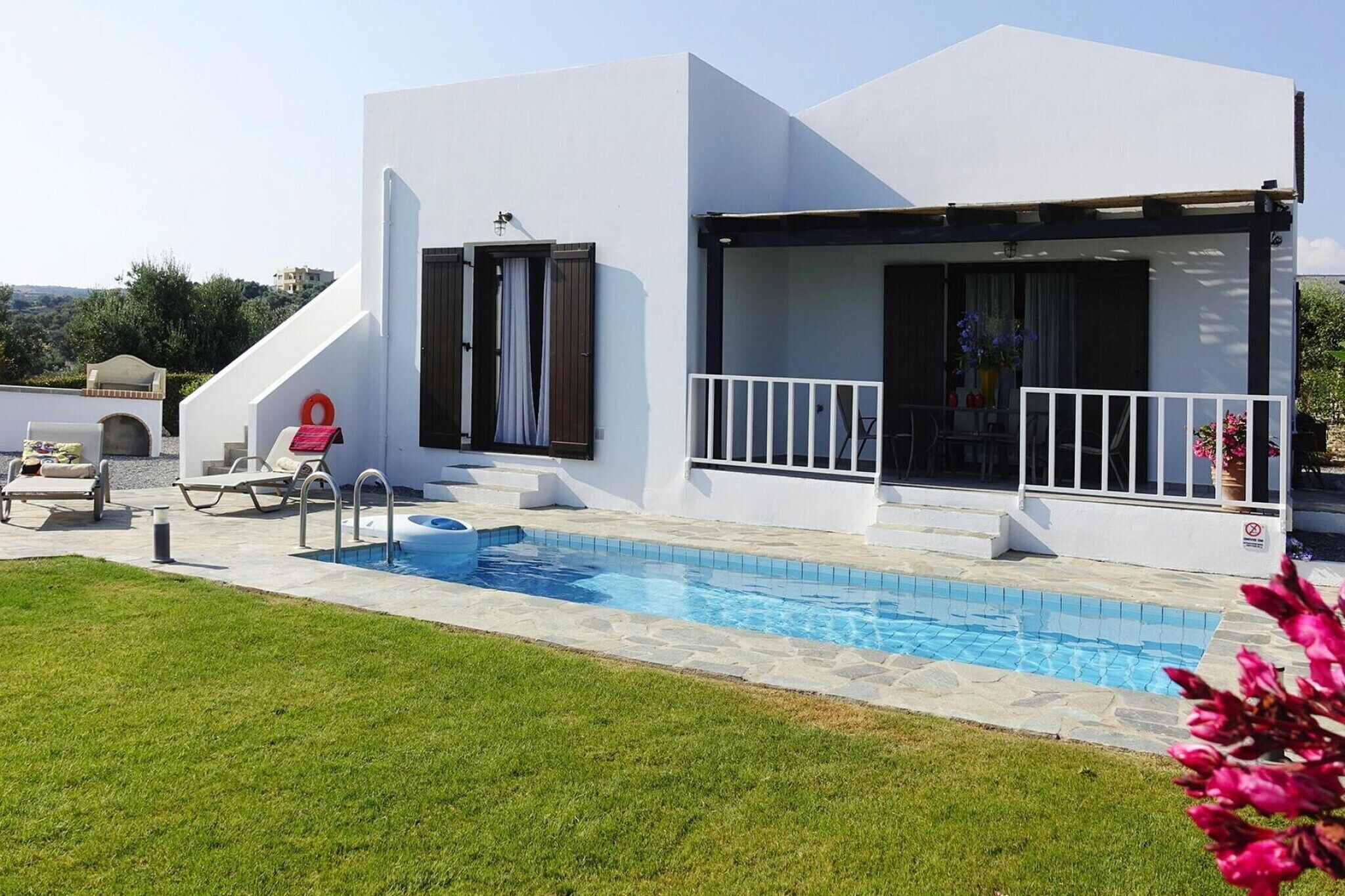 Une villa moderne dotée d’une piscine, d’un espace salon extérieur et d’un patio couvert.