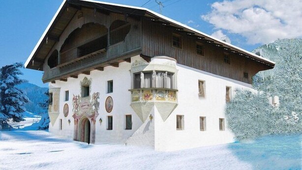 A traditional chalet with a sloped roof, wooden balconies, and a decorative facade. - Apartment in Itter near Wilder Kaiser Ski Area (Itter)