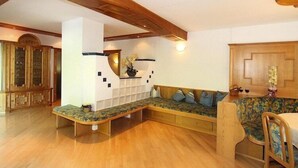 A cozy living room with a built-in bench, wooden furniture, and a decorative vase. - Apartment in Itter near Wilder Kaiser Ski Area (Itter)