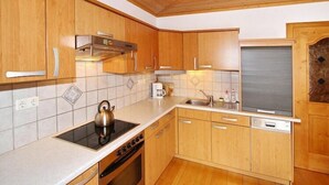 Une cuisine avec des meubles de rangement en bois, une cuisinière et un évier.