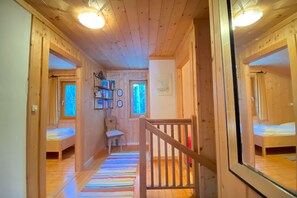 Cozy cabin-style accommodation with a central staircase, seating area, and bookshelf.
