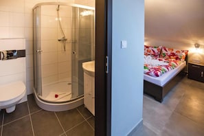 Une salle de bain avec douche, toilettes et lavabo.