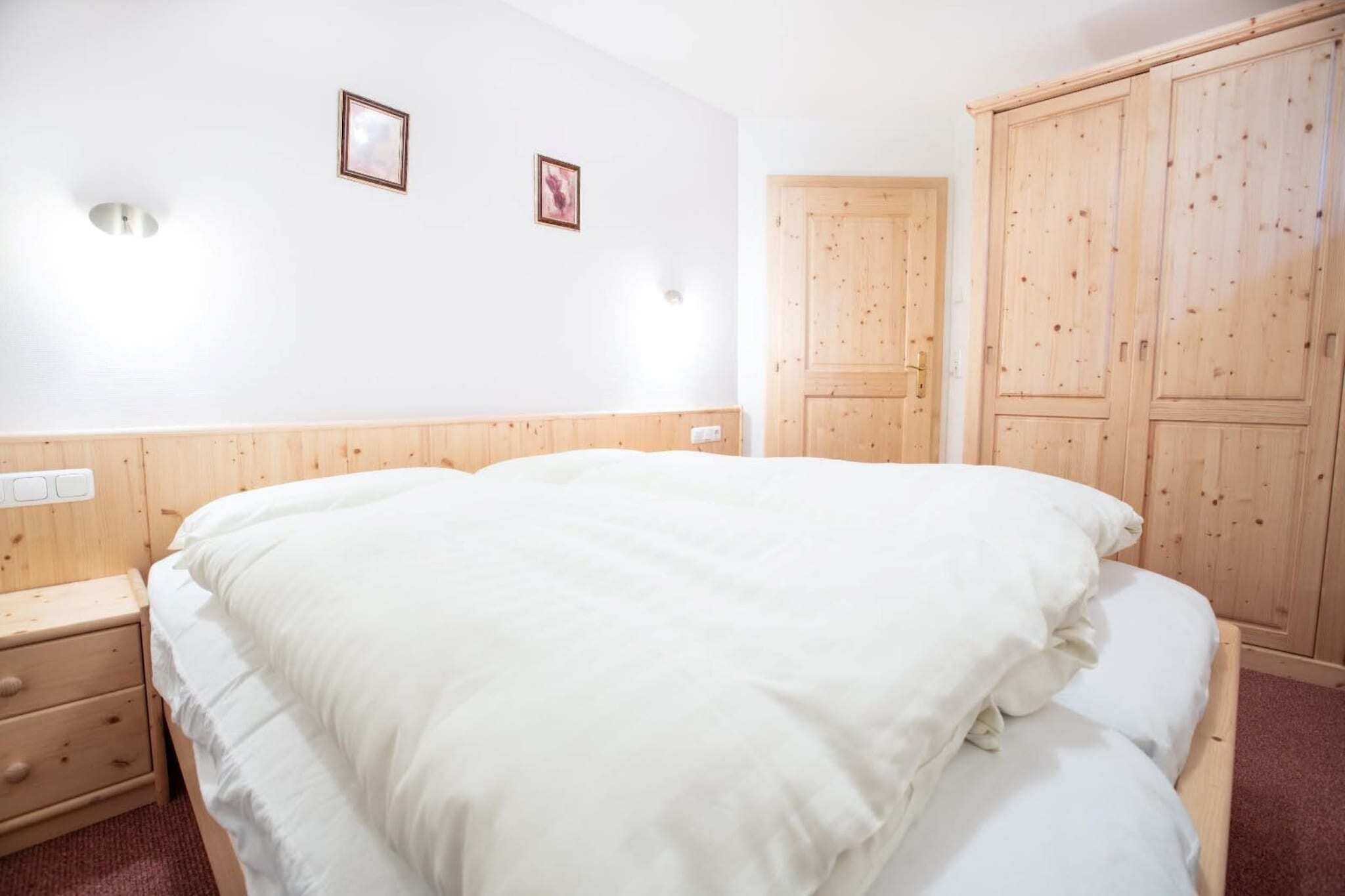 Ein Schlafzimmer mit einem großen Bett, einem Holzschrank und zwei Wandleuchten.