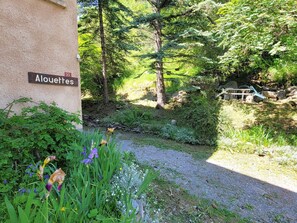 Ein Gebäude mit dem Schriftzug "Alouettes" und ein Kiesweg, der zu einem bewaldeten Gebiet führt.