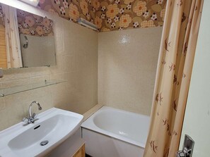 Un bagno con lavandino, specchio e vasca da bagno.