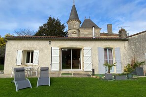A house with a tower, a patio with chairs, and a small garden. - Semi-detached house on a vineyard, Talais (Talais)