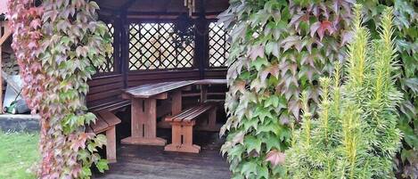 A wooden gazebo with benches and a lattice wall.