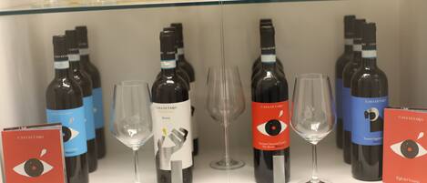 A display of wine bottles and glasses on a shelf.