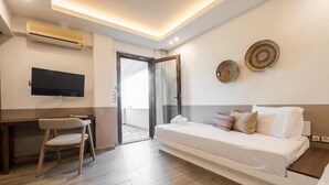 A modern bedroom with a bed, a desk, and a chair. - Gerakini Poolside Holiday Apartment (Gerakini)