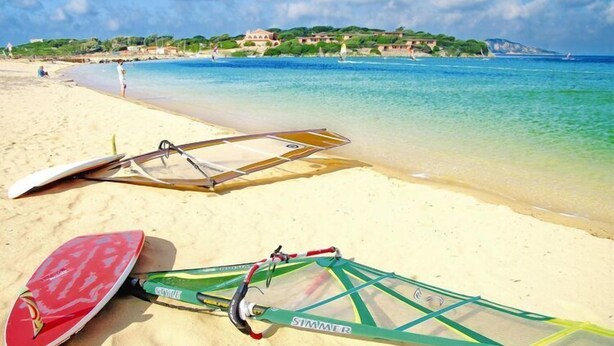 Une plage avec deux planches de planche à voile et une planche de stand-up paddle.