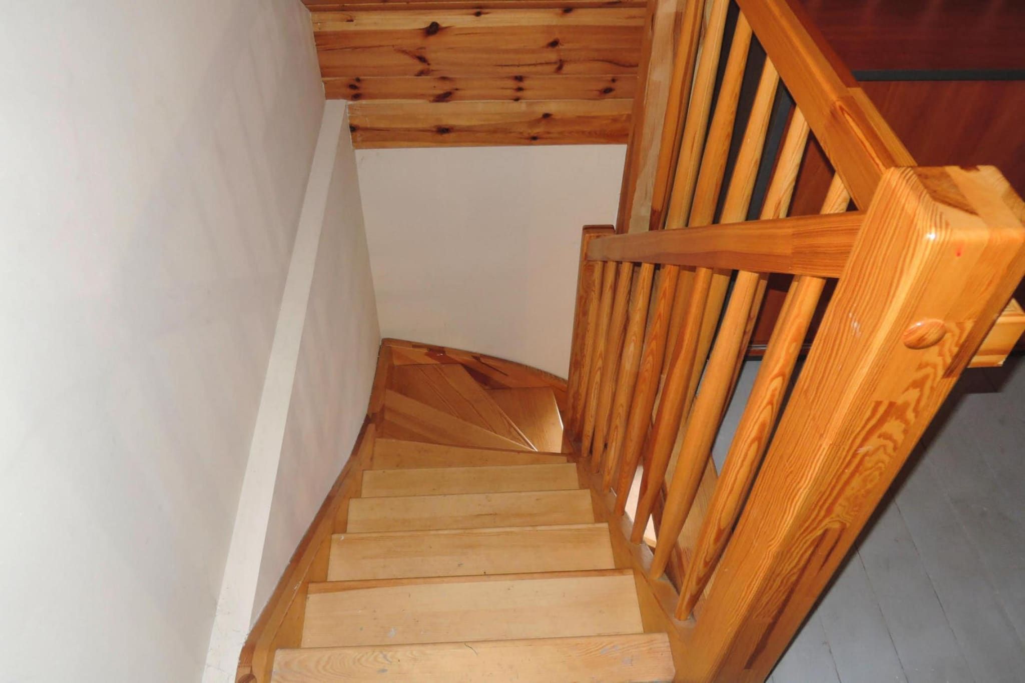 Un escalier en bois avec une rampe et des marches en bois.