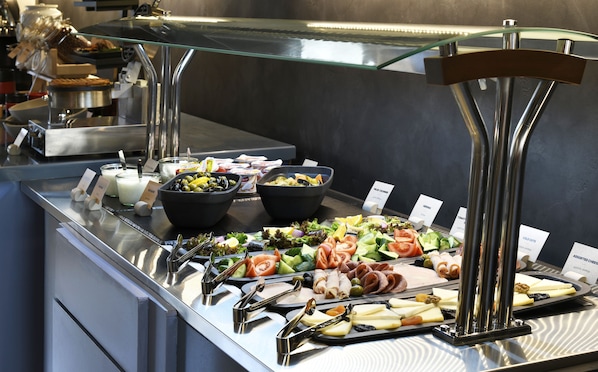 A buffet with various food items including salads, cheeses, and meats. - Ibis Tbilisi Stadium (Tbilisi)