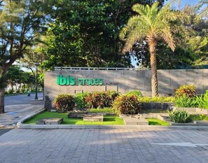 «ibis Styles Vung Tau» -hotellin kyltti, jonka edessä on kauniisti maisemoitu puutarha.