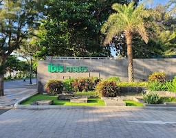 Señalización de 'ibis Styles Vung Tau' con un jardín ajardinado en primer plano.