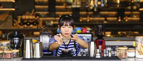 A barista at work in a kitchen with coffee-making equipment and ingredients.
