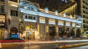 A hotel with a grand entrance, a large illuminated sign, and classical architectural details. - Sofitel Istanbul Taksim (Istanbul)