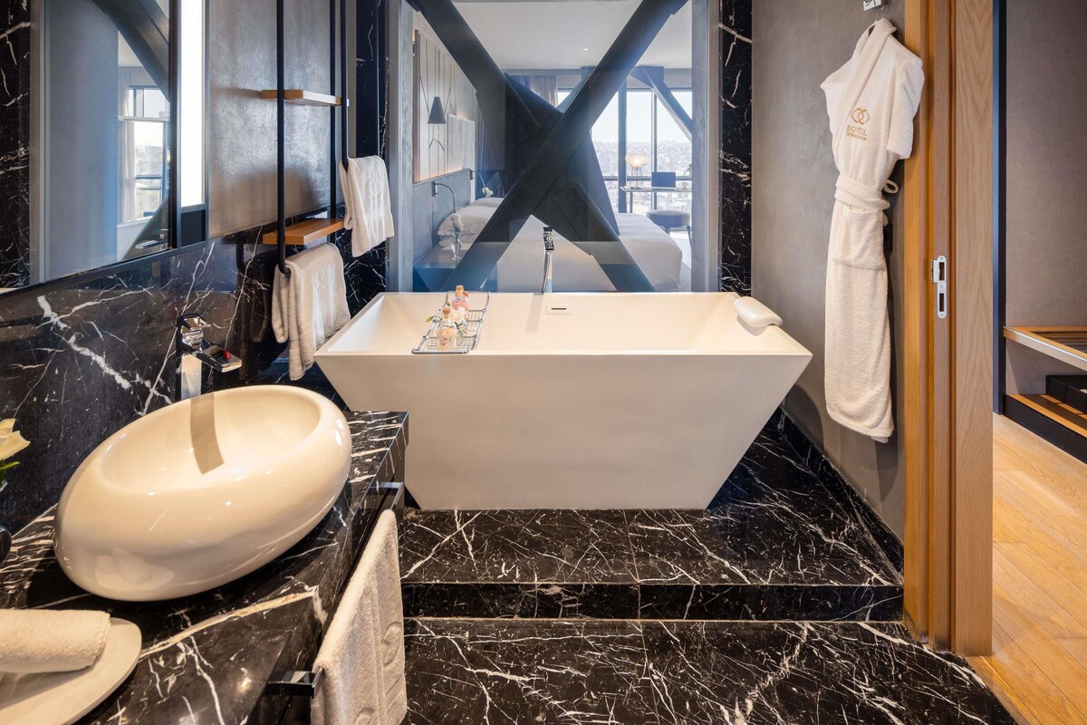A modern bathroom with a freestanding bathtub, a large oval sink, and a mirror.