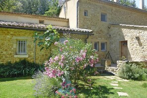 A stone building with a garden in front.
