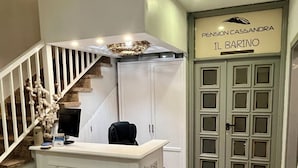 A reception desk with a marble front, a staircase with white railings, and a door labeled "Pension Cassandra Il Barino". - Pensión Cassandra (Arona)