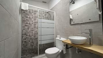 Habitación individual | Baño | Ducha, secador de pelo y toallas