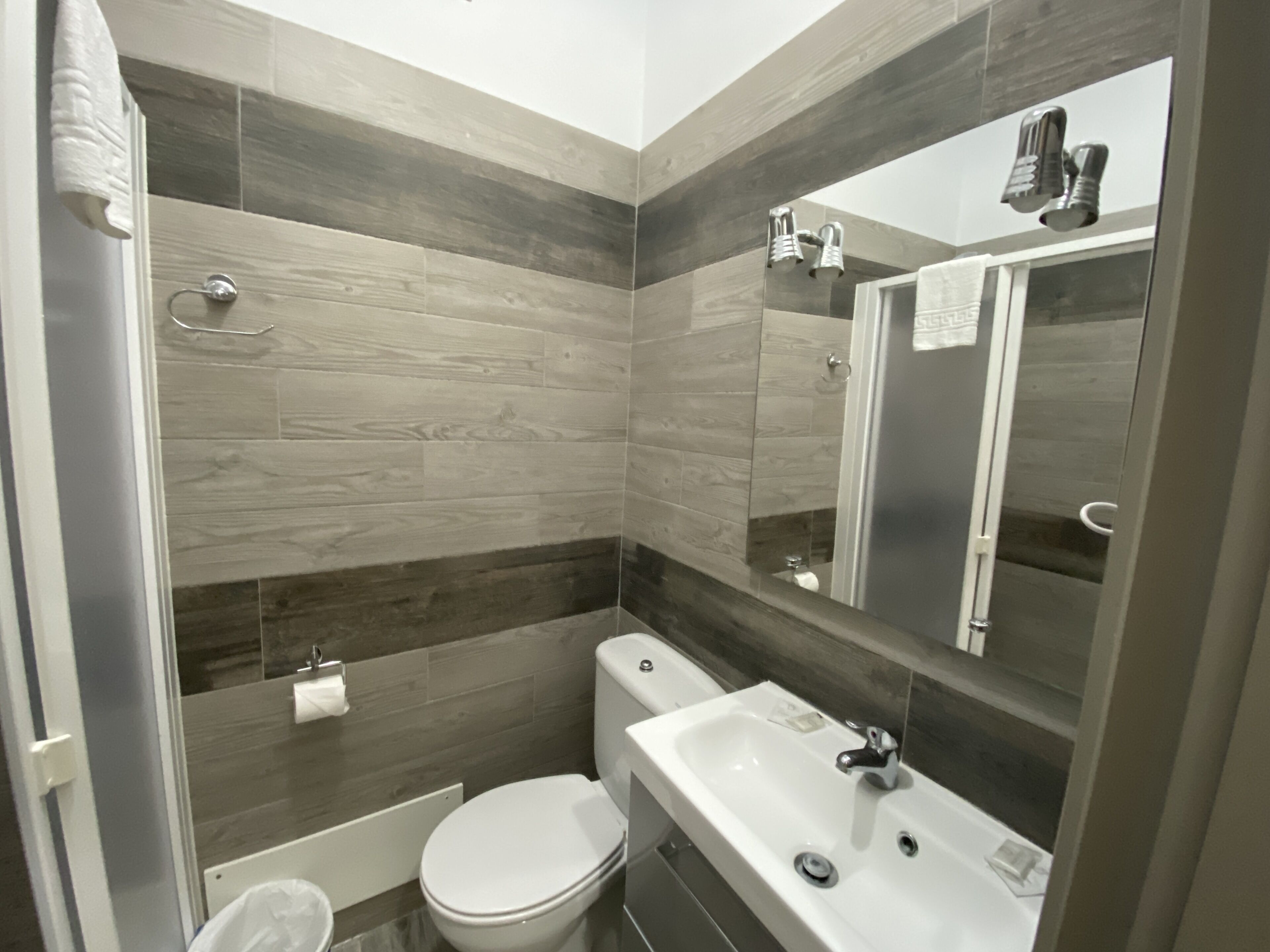 A modern bathroom with a toilet, sink, and shower area.