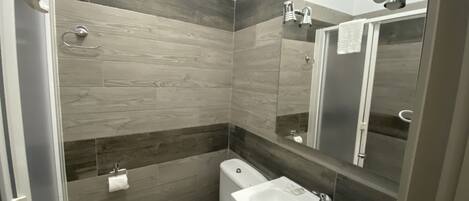 A modern bathroom with a toilet, sink, and shower area.