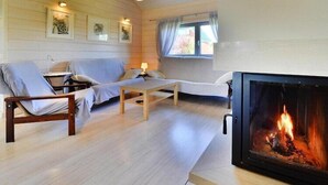 Un salon chaleureux avec une cheminée, des murs en bois et un canapé.