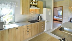 Une cuisine de taille réduite, dotée de meubles de rangement en bois, d’une cuisinière encastrée et d’un évier.