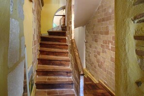 A staircase with wooden steps and a brick wall on one side.