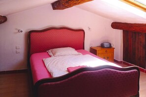Un dormitorio con una cama, una mesita de noche y un cabecero de madera.