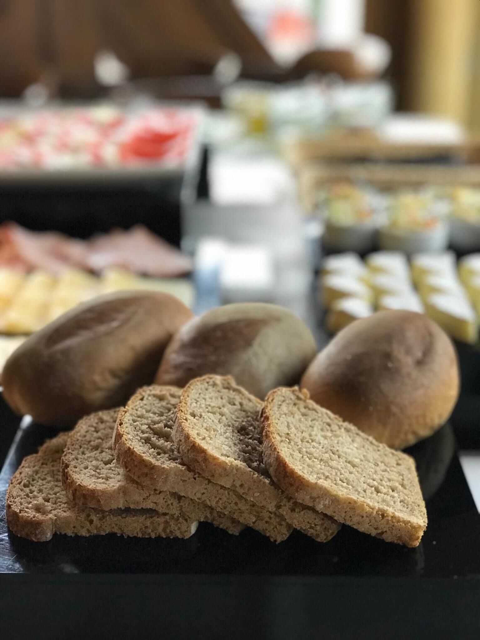Slices of whole grain bread on a black plate.