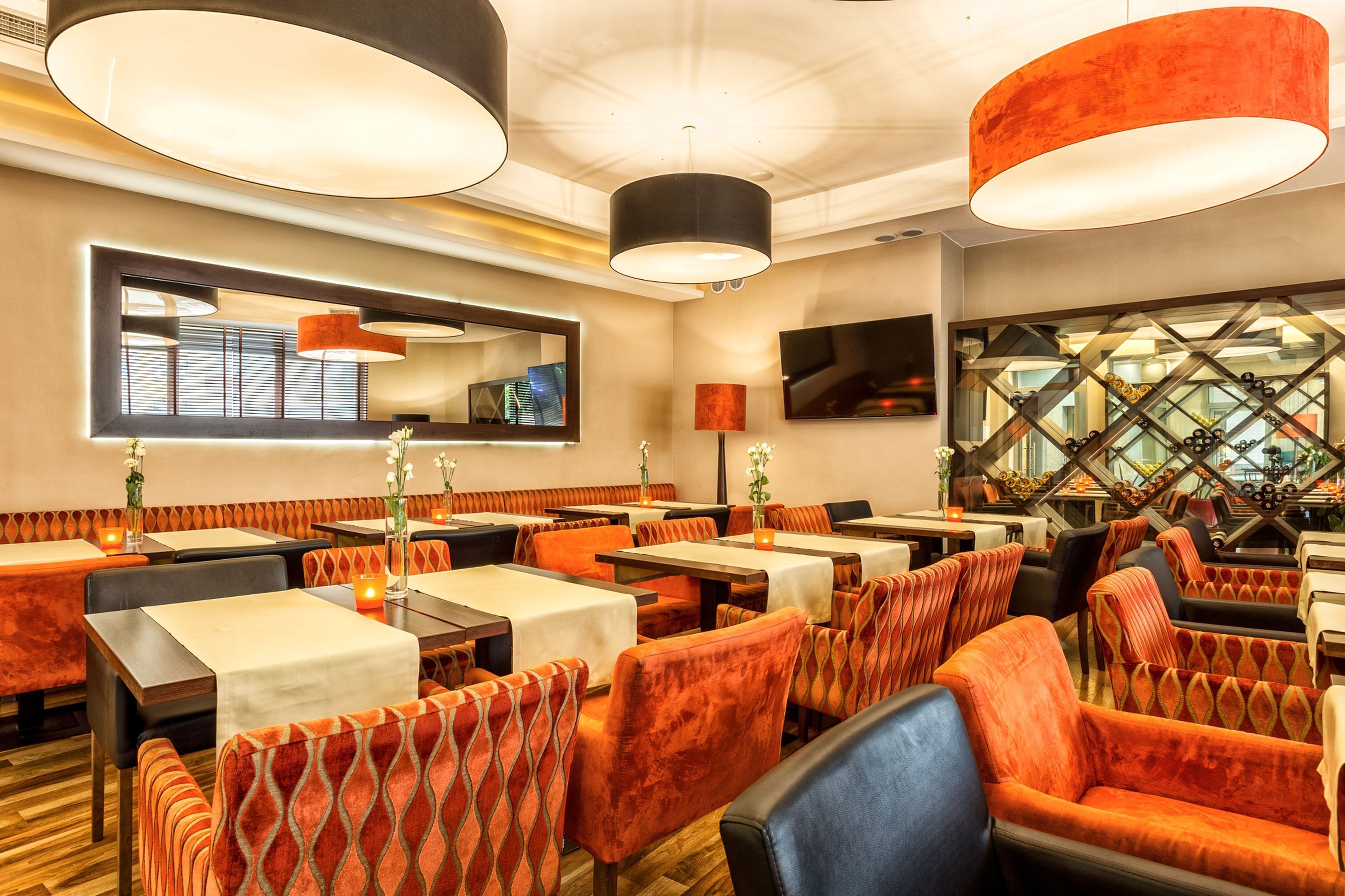A restaurant with booths and tables, warm lighting, and a modern interior design.