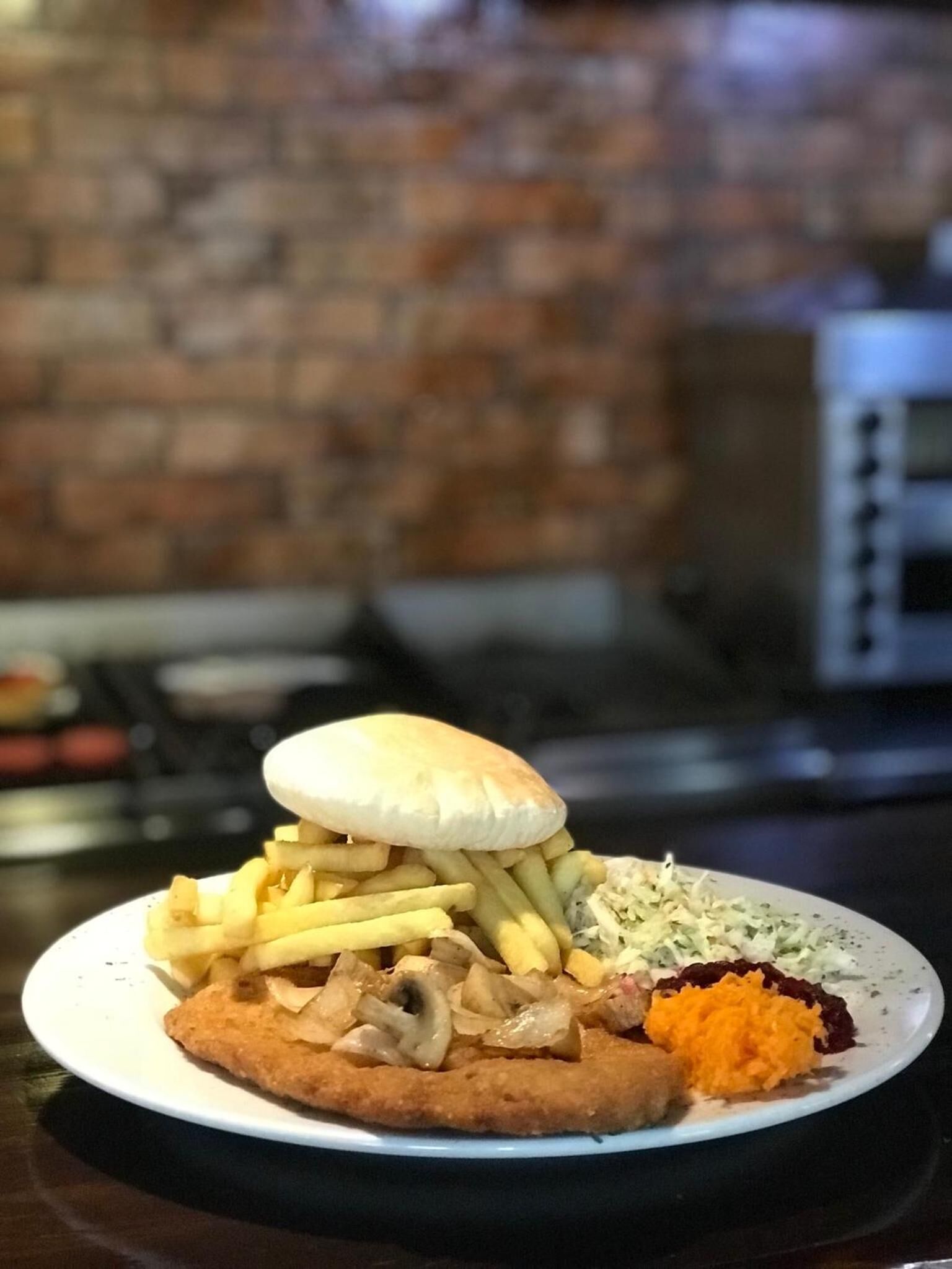 Un plato con un sándwich, papas fritas y una guarnición de ensalada de col.