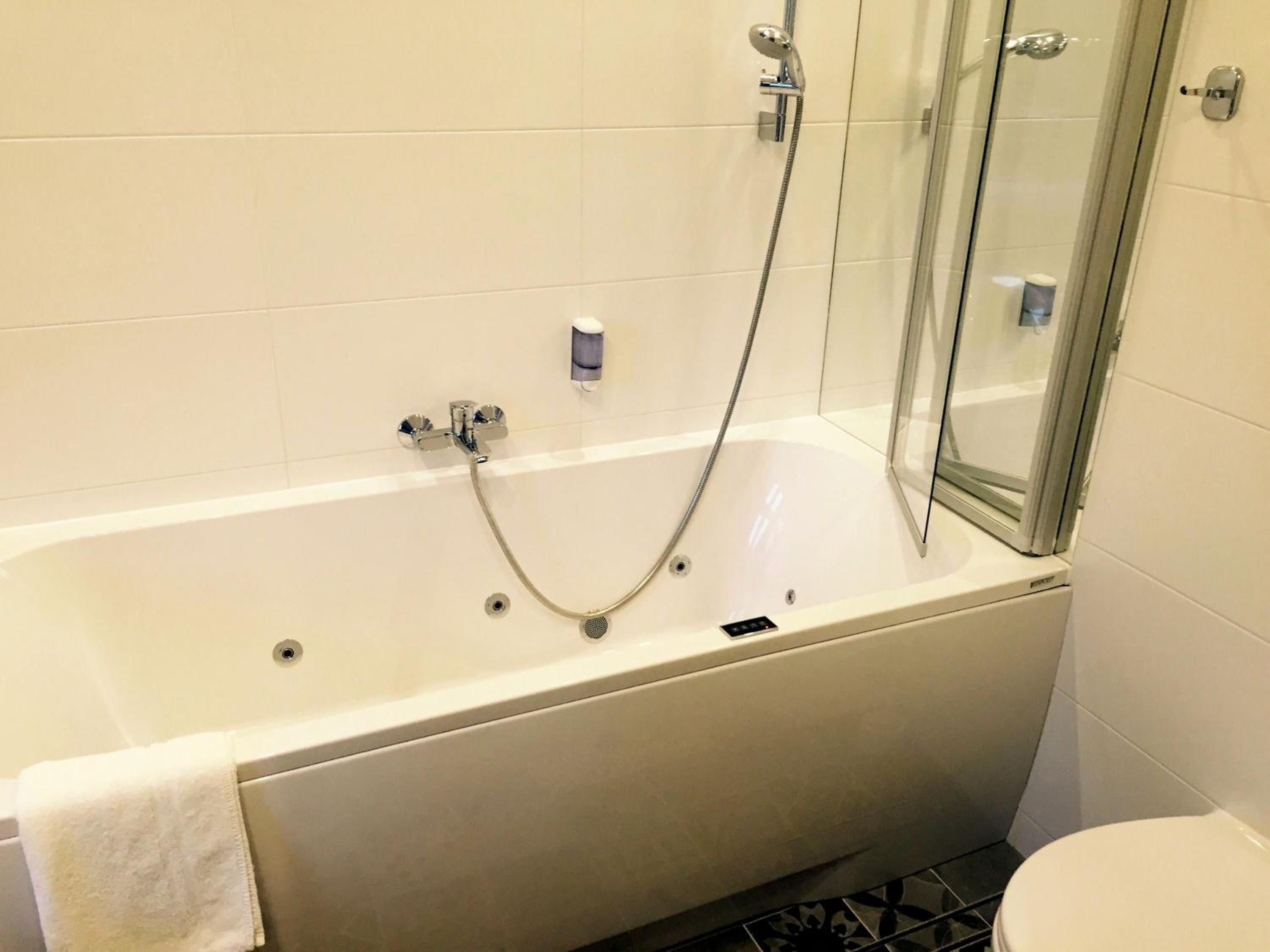 Ein Badezimmer mit Badewanne, Duschkabine und Toilette.