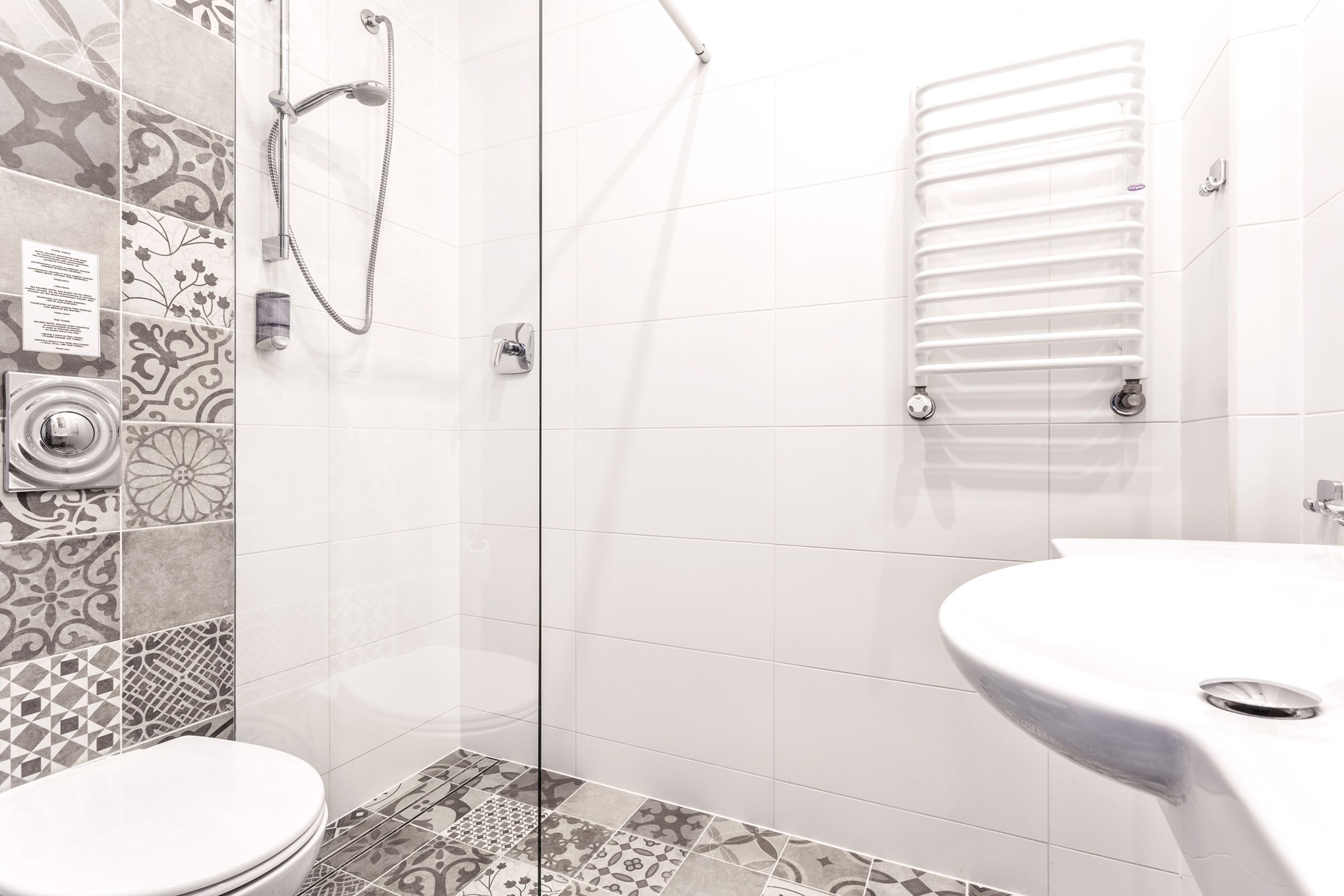 A modern bathroom with a shower, toilet, and sink.