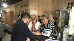 Un espace bar avec un comptoir, des tabourets et un ordinateur portable posé sur le comptoir.