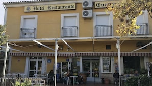Un bâtiment jaune avec une enseigne indiquant « Hôtel-restaurant » et « Cuentros ».