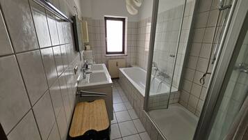 Une salle de bain moderne avec une baignoire, une douche et un lavabo.