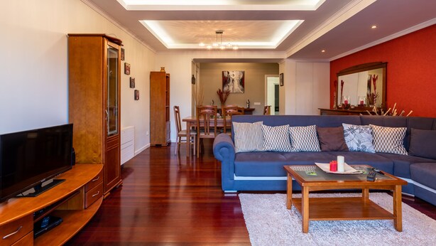 A living room with a TV, sofa, coffee table, and wooden cabinet. - Casa Branca II (Funchal)