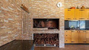 Eine Küche mit Backsteinwand, Holzschrank und einer Uhr.