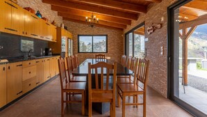 Eine moderne Küche mit Holzschränken, einer Granit Arbeitsplatte und einem Essbereich mit großem Tisch und Stühlen.