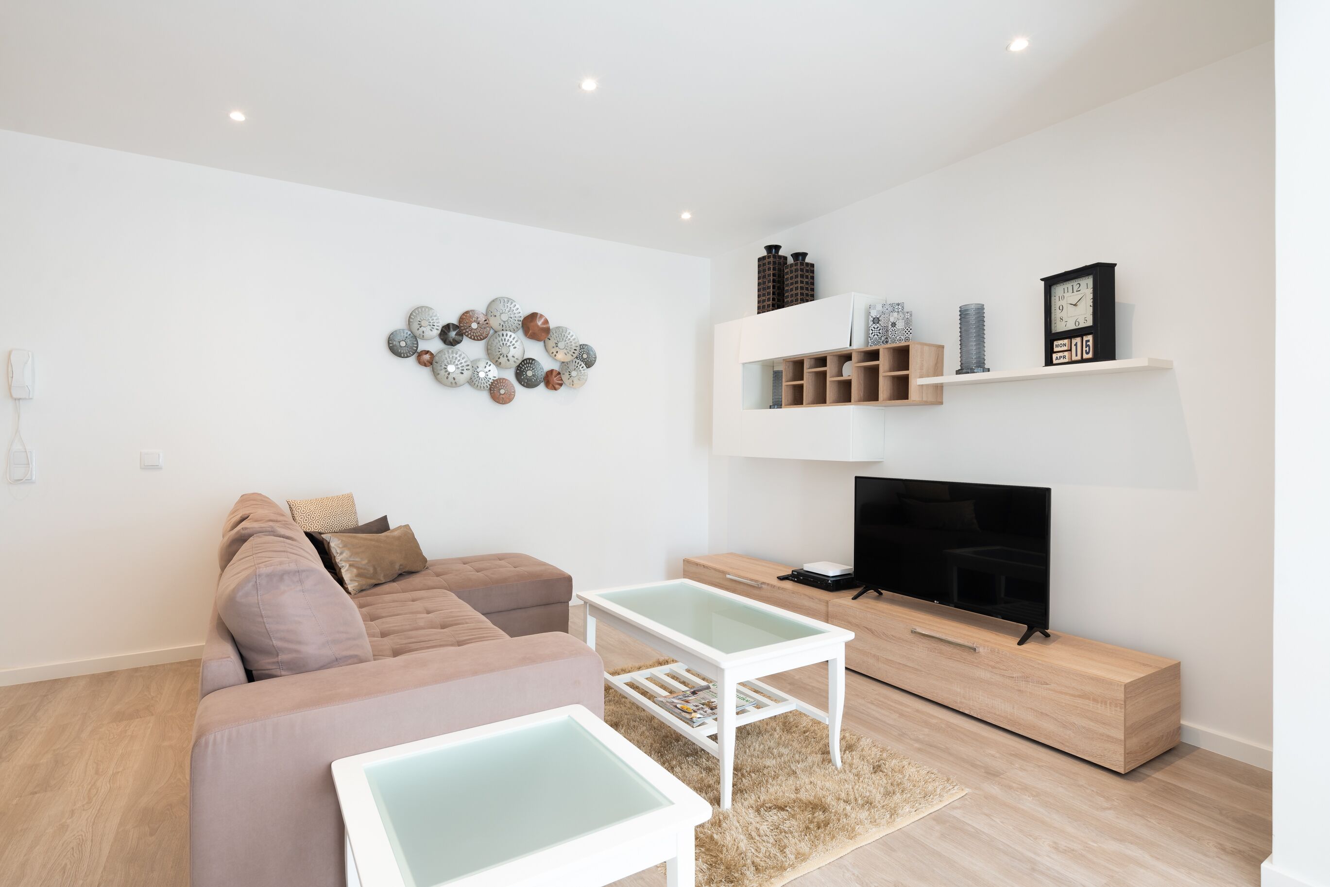A modern living room with a sectional sofa, a flat-screen TV, and a coffee table.