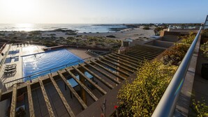 A rooftop pool with a view of the beach and ocean.