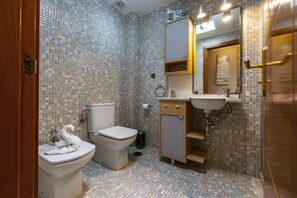 A bathroom with a mosaic tile floor, a toilet, a sink, and a mirror. - Beach Apartment Marfolin 19 El Cotillo (La Oliva)