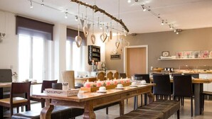 A cozy restaurant with a wooden table set for dining, surrounded by chairs. - Hotel am Kellhof (Hilzingen)